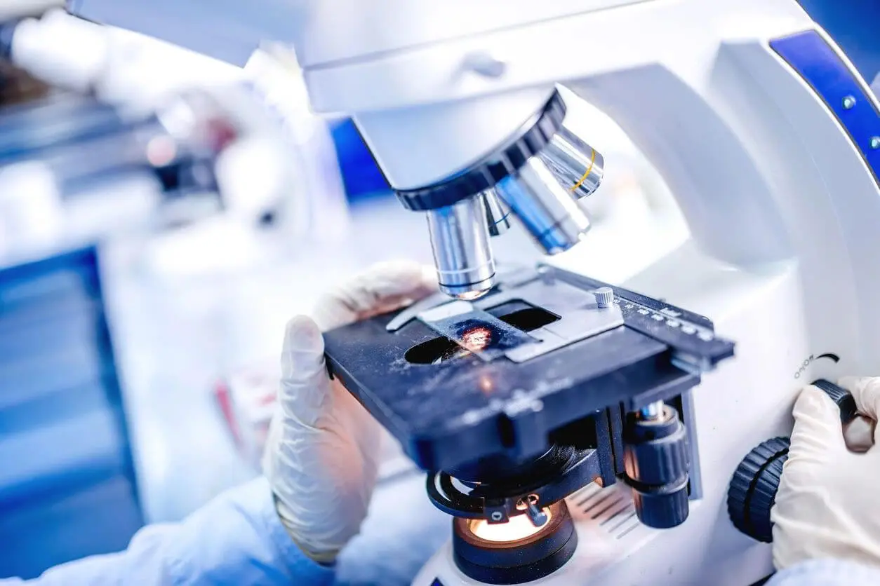 A person working with a microscope in a lab.